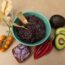 black bean recipe cooked up in a bowl with tomatoes red peppers avocado and red onion on the side for garnish