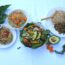 Table of healthy vegan food including a salad with seasoned tofu whole wheat pasta quinoa legumes and brown rice