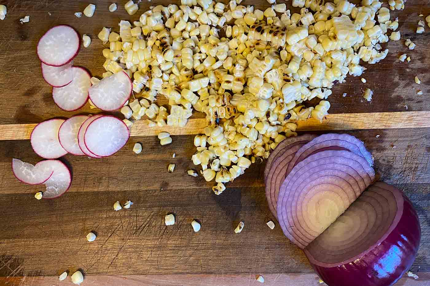 sliced radish corn off the cob and sliced red onion