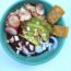 vegan burrito bowl with red onion avocado vegan Cotijo cheese radishes chips beans and brown rice