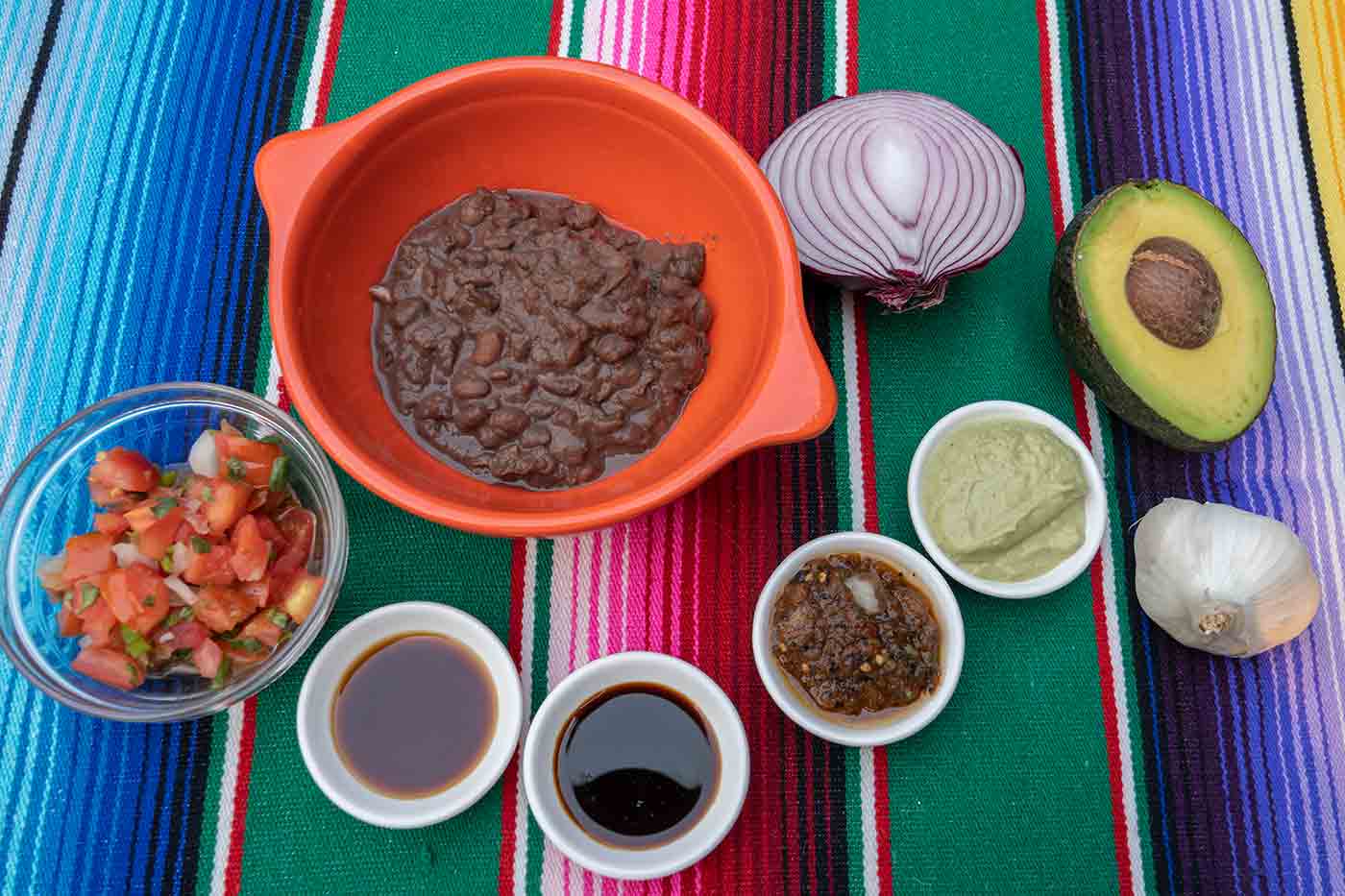 Tacodeli ingredients including beans soy sauce vinegar salsas and pico de gallo