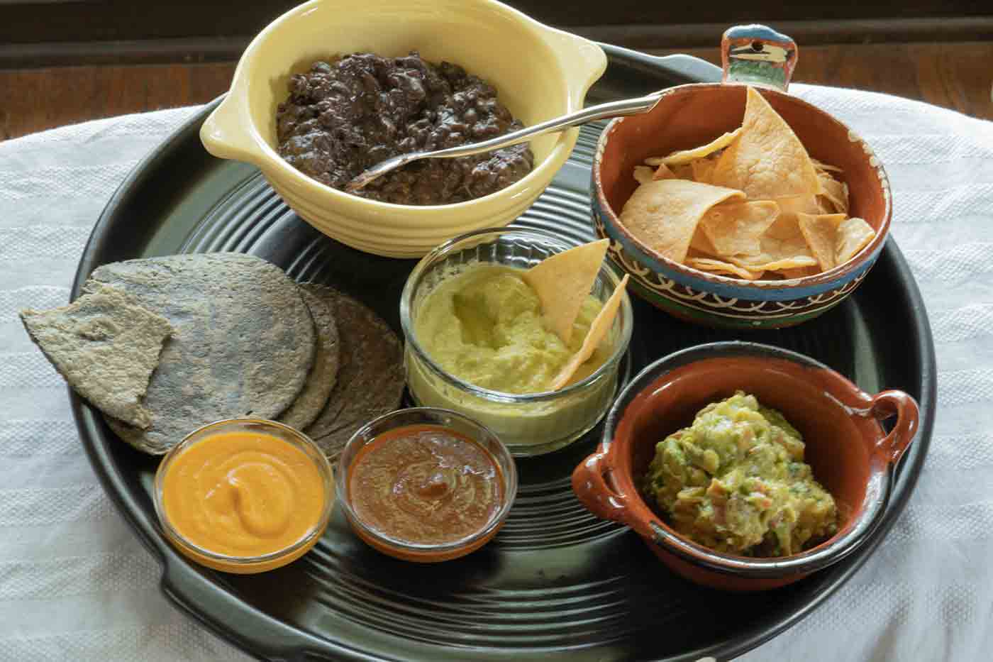 jalapeno sauce and other salsas with guacamole and beans and blue corn tortillas