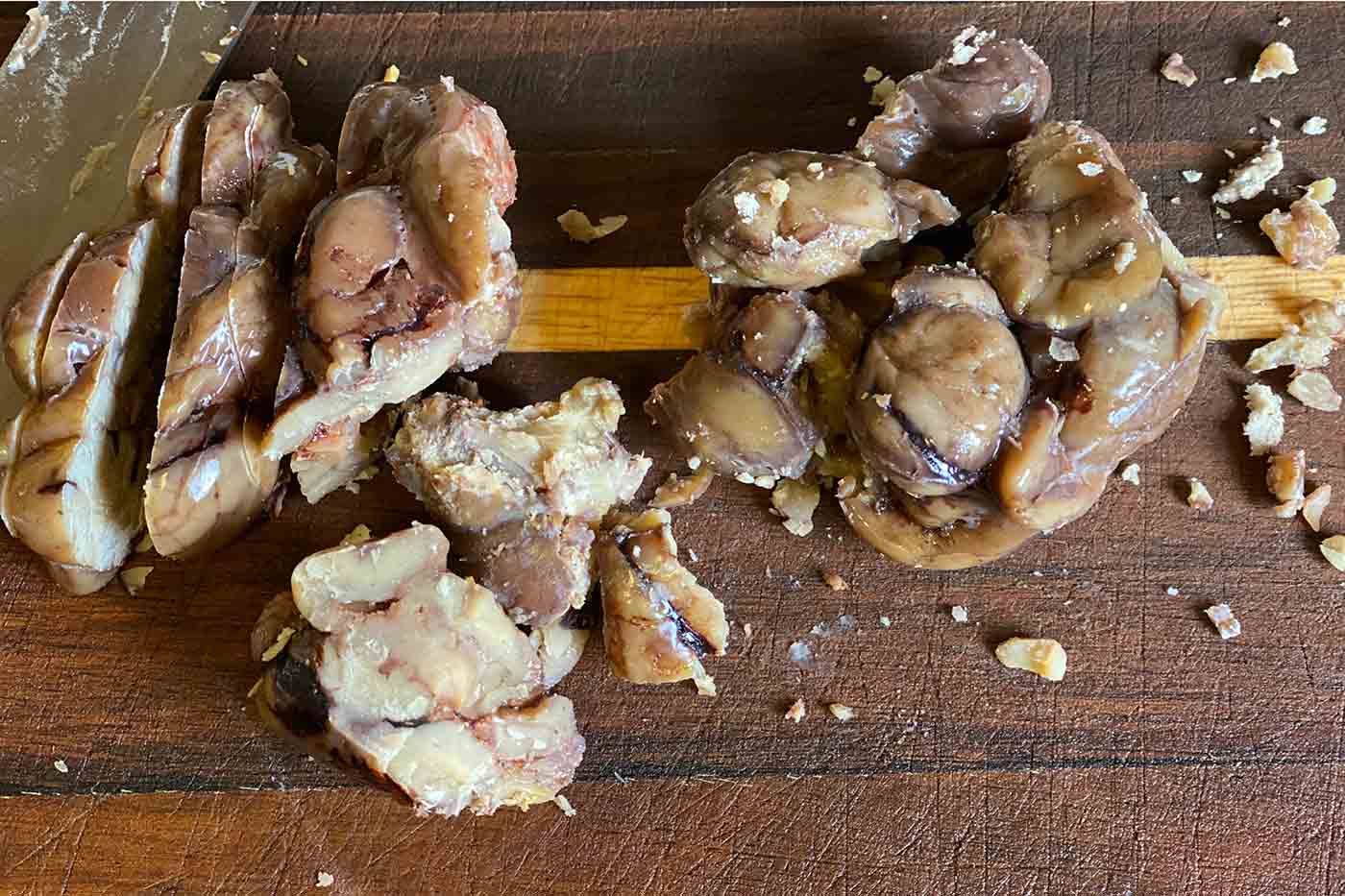 cooked chestnuts sliced on a cutting board